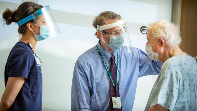 Dr. M. Shane Chapman and medical assistant Kate Yamahiro treat a dermatology patient. 